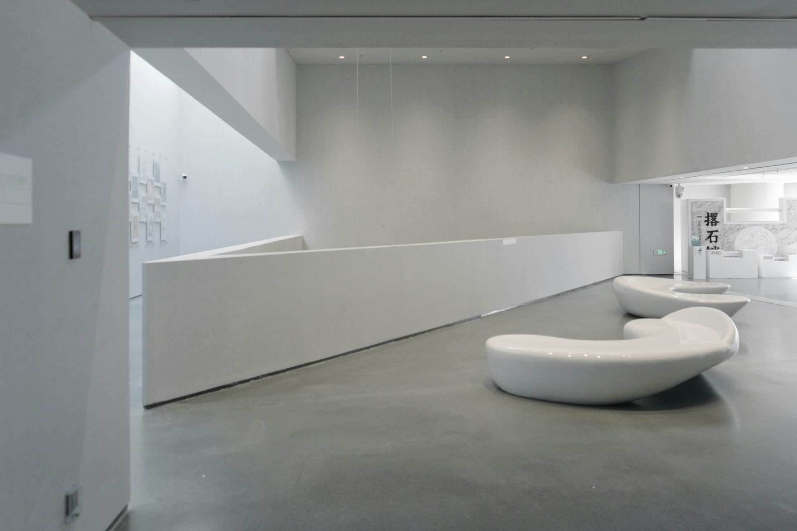 Minimal white gallery interior with sculptural seating