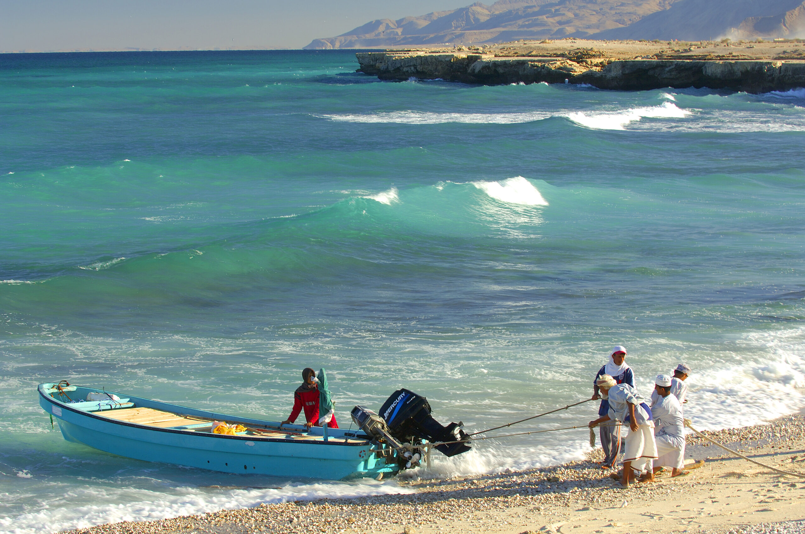 Fishermen pulling a boat onto Sur Beach in Oman