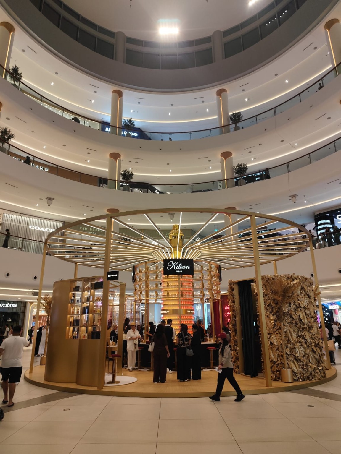 Wide architectural view of the golden KILIAN PARIS installation in The Dubai Mall atrium